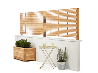 RHS Prestige Slatted Panels on top of a white wall with a contemporary planter and garden table